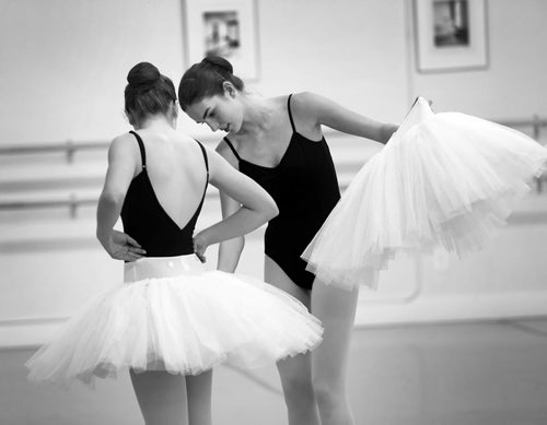 Brandon Sun Taylor Lewis helps a fellow dancer with her tutu for a ballet rehearsal at the Brandon School of Dance. (Bruce Bumstead/Brandon Sun)