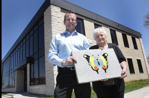 Michel Morin, owner of North Winds property management company on Main St. at Anderson Ave.  is leading two "pay it forward" types of community development initiatives in the North End. He is with Leona Schroeder, a member of the Manitoba Master Gardener Association with a stain glass butterfly design on a patio block she made for the community butterfly garden she and students from Champlain School will build along the side the building . Ashley Prest story (WAYNE GLOWACKI/WINNIPEG FREE PRESS) Winnipeg Free Press May 23 2013