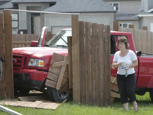 Colleen Fredrickson was preparing her lunch in her home on Aldgate Rd. at Elsey Rd. Friday when a pickup truck crashed through the fence striking the air conditioner unit of her home. The the driver wasn't injured.  (WAYNE GLOWACKI/WINNIPEG FREE PRESS) Winnipeg Free Press May 24 2013