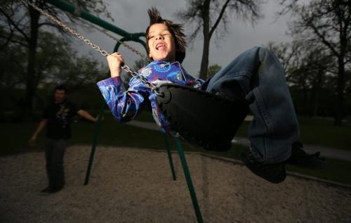 Keith Perry pushes his son, Merik, 6, on the swings in Fort Rouge Park, Friday, May 24, 2013. GPS Coordinates: 49.88N and -97.14 W. For new section next week?? (TREVOR HAGAN/WINNIPEG FREE PRESS)