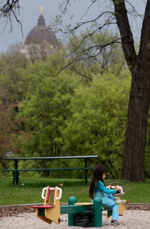 Arianna Perry, 4, empties rocks out of her shoe in Fort Rouge Park, Friday, May 24, 2013. The Manitoba Legislative Building in the background. GPS Coordinates: 49.88N and -97.14 W. For new section next week?? (TREVOR HAGAN/WINNIPEG FREE PRESS)