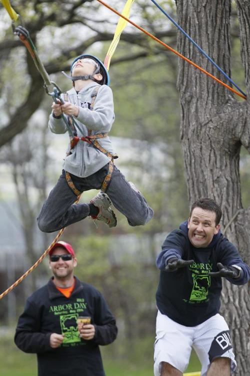 May 25, 2013 - 130525  - Aiden Friesen (10) does the zipline with the help of volunteer Ray Perron (R) of Alliance Tree Care during the Arbor Day activities in Assiniboine Park in Winnipeg Saturday, May 25, 2013. John Woods / Winnipeg Free Press
