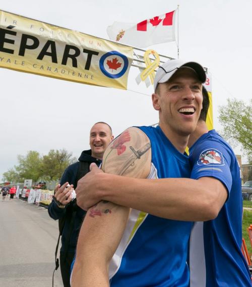 Cpl. Jean Francois Dion is congratulated at the end of his own double marathon at Sunday's RCAF run. The Afghanistan veteran ran a gruelling 85-kilometres over the Highway of Heroes from Portage la Prairie to raise awareness for the Canadian Forces Soldier On program, which helps ill and injured military members get back into fitness and sports, as well as the Canadian Cancer Society. 130526 - Sunday, May 26, 2013 - (Melissa Tait / Winnipeg Free Press)