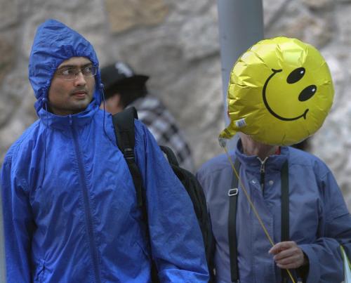 Keeping Smiling Winnipeg- Two people wait for a bus in the rain in downtown Winnipeg Thursday- Winnipeg could see 65 mm of rain in the next 36 hours as a Colorado low passes through-May 30, 2013  (JOE BRYKSA / WINNIPEG FREE PRESS)