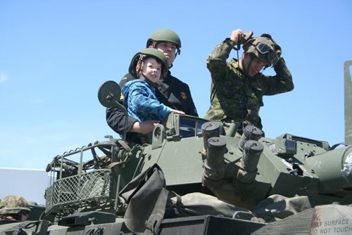 Six-year-old Jacob Keddy takes a ride on a tank with his father, Matthew and commander Kevin Vanerzwaag during Family Day at CFB Shilo on Saturday afternoon. The event, which attracted around 400 people to the base, comes weeks before the final deployment of 350 Shilo soldiers to Afghanistan serving with Operation Attention, a mission based in Kabul focused on the training of the Afghan National Army.  (Graeme Bruce/ Brandon Sun) June 1, 2013.