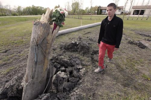 June 3, 2013 - 130603  -  On  Monday, June 3, 2013 Kyle Dech visits a memorial of flowers and tobacco for two young women who died when their car left River Road in St. Andrews and collided with this Hydro pole early Saturday morning. Dech was the first person on scene. John Woods / Winnipeg Free Press