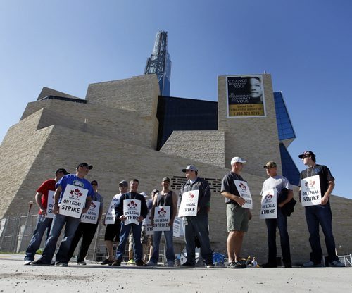 Pipefitters on the picket line in front of a gate to the the Canadian Museum for Human Rights Wednesday morning, other members are also picketing the site of the Investors Group Field.  (WAYNE GLOWACKI/WINNIPEG FREE PRESS) Winnipeg Free Press June 5 2013 CMHR