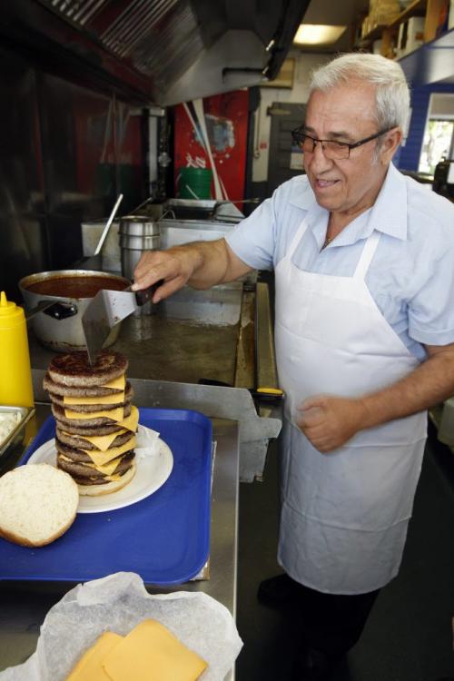 Angelo Corantzopoulos stacks burger pattys - Super Boy's Family Restaurant owners Angelo and Georgia with 9 patty burger  a former record at at one time by a customer -  in some pics , owner Georgia  Chouzouris  and Angelo Corantzopoulos with giant super burger - to be published in Saturday section june 16 with Superman feature .story by dave sanderson  KEN GIGLIOTTI / JUNE 5 2013 / WINNIPEG FREE PRESS