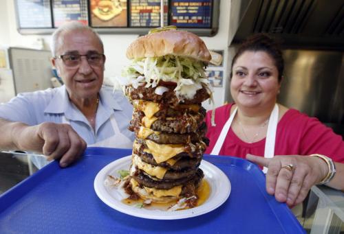 Super Boy's Family Restaurant owners Angelo and Georgia with 9 patty burger  a former record at at one time by a customer -  in some pics , owner Georgia  Chouzouris  and Angelo Corantzopoulos with giant super burger - to be published in Saturday section june 16 with Superman feature .story by dave sanderson  KEN GIGLIOTTI / JUNE 5 2013 / WINNIPEG FREE PRESS