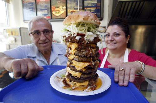 Super Boy's Family Restaurant owners Angelo and Georgia with 9 patty burger  a former record at at one time by a customer -  in some pics , owner Georgia  Chouzouris  and Angelo Corantzopoulos with giant super burger - to be published in Saturday section june 16 with Superman feature .story by dave sanderson  KEN GIGLIOTTI / JUNE 5 2013 / WINNIPEG FREE PRESS