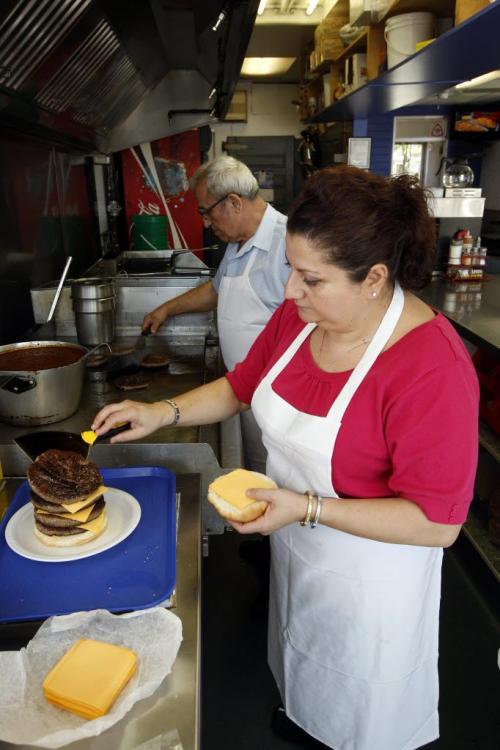 Building the burger- Super Boy's Family Restaurant owners Angelo and Georgia with 9 patty burger  a former record at at one time by a customer -  in some pics , owner Georgia  Chouzouris  and Angelo Corantzopoulos with giant super burger - to be published in Saturday section june 16 with Superman feature .story by dave sanderson  KEN GIGLIOTTI / JUNE 5 2013 / WINNIPEG FREE PRESS