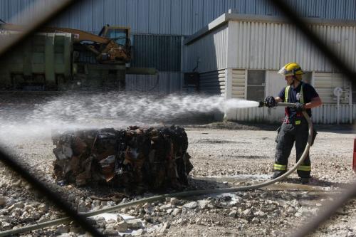 Firefighters extinguish one of dozens of bales of recycled cardboard that caught fire Thursday morning at Industrial Metals at 550 Messier St in St Boniface  Fire crews expect to be on scene for awhile until - June 06, 2013   (JOE BRYKSA / WINNIPEG FREE PRESS)