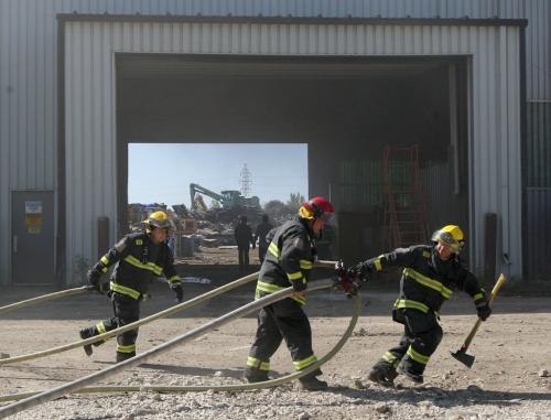 Firefighters  move hoses into position extinguish one of dozens of bales of recycled cardboard that caught fire Thursday morning at Industrial Metals at 550 Messier St in St Boniface  Fire crews expect to be on scene for awhile until - June 06, 2013   (JOE BRYKSA / WINNIPEG FREE PRESS)