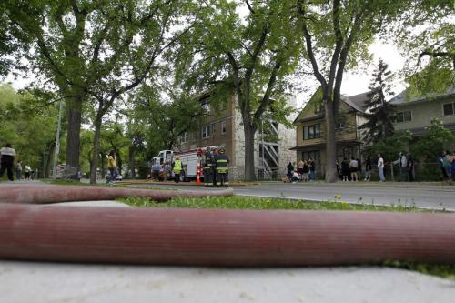Residents sit outside with firefighters and paramedics on the scene of a fire in an apartment building on the 400 block of Maryland Street, Saturday, June 8, 2013. (TREVOR HAGAN/WINNIPEG FREE PRESS)