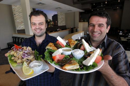 George Simeonidis and Stavros Chatjiathanasiadis own the Santa Lucia restaurant on Corydon. They hold the calamari and Greek Sampler plate. June 10, 2013  BORIS MINKEVICH / WINNIPEG FREE PRESS
