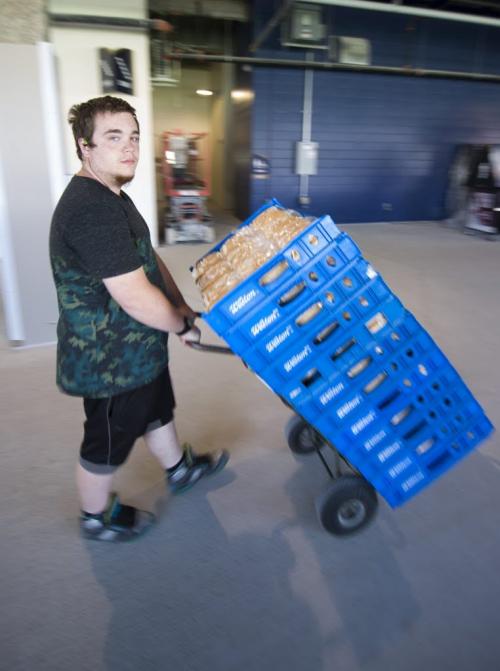 Wednesday June 11, 2013 - Winnipeg - DAVID LIPNOWSKI / WINNIPEG FREE PRESS  Phoenix Gibson hauls racks of buns, as staff get ready for the first Winnipeg Blue Bombers home game. As seen on tour of the concessions at Investors Group Field.