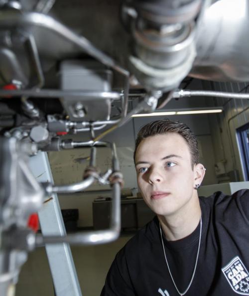 Twenty year old aircraft maintenance apprentice Dylan Pereira takes a peek beneath an engine at the Red River College Stevenson Campus by the Canadian Forces base on Saskatchewan Ave. He will be representing Canada at the World Skills competition beginning July 2 in Leipzig, Germany. Wednesday, June 12, 2013 (MCNEILL) (JESSICA BURTNICK/WINNIPEG FREE PRESS)