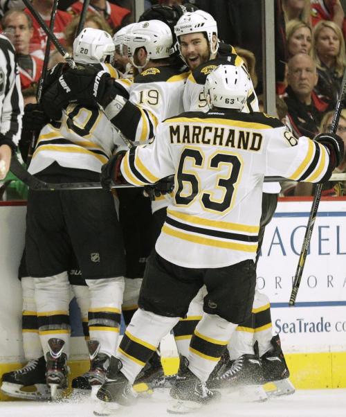 Boston Bruins left wing Daniel Paille (20) is mobbed by teammates Adam McQuaid (54), Brad Marchand (63), and Tyler Seguin (19), after scoring in overtime against the Chicago Blackhawks during Game 2 of their NHL Stanley Cup Finals hockey series in Chicago, Illinois, June 15, 2013.  REUTERS/John Gress (UNITED STATES  - Tags: SPORT ICE HOCKEY)   - RTX10PF0