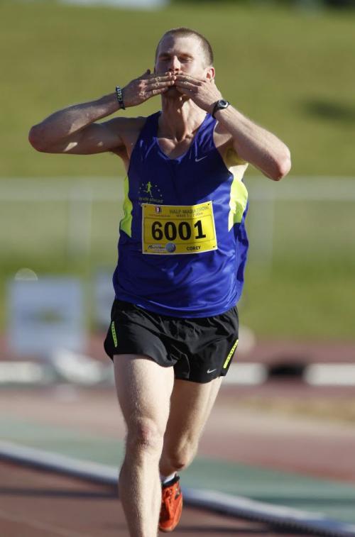 Corey Gallagher salutes the crowd in University Stadium as he wins the half marathon with a time of 1:10:50, at the 35th Manitoba Marathon, Sunday, June 16, 2013. (TREVOR HAGAN/WINNIPEG FREE PRESS)