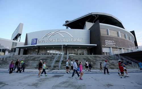 Participants and supporters pass Investors Group Field on the way to the start line at the University of Manitoba around 6am prior to the 35th Annual Manitoba Marathon, Sunday, June 16, 2013. (TREVOR HAGAN/WINNIPEG FREE PRESS)