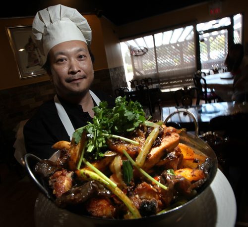 Jun Yang holds "Chicken in an Iron Wok" at his "Golden Loong Restaurant". See Marion's review.   June 17, 2013 - (Phil Hossack / Winnipeg Free Press)
