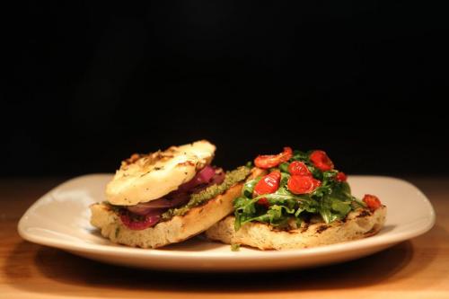 Grilled Haloumi cheese Sandwich. Haloumi cheese is grilled along with Foccacia Bread, red peppers and purple onion.  Pumpkin See spread in spread on bottom of sandwich along with grilled cheese and onion.  Sandwich is served with grilled red peppers and fresh greens topped with oven dried cherry tomatoes. Red River College Culinary Arts cooking course.  Photography by Ruth Bonneville Winnipeg Free Press June 15,, 2013