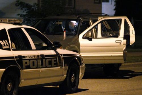 June 17, 2013 - 130617  -  Winnipeg police officer goes through a car near a drive by shooting at 2238 Gallagher Avenue West at about 11:30 Monday evening, June 17, 2013. John Woods / Winnipeg Free Press