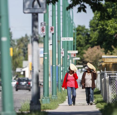 (Left to right) Friends Gloria Borja and Leonisa Rasonabe shade their faces from the sun's harsh rays during a stroll down Mountain Ave. the morning of Tuesday, June 18, 2013. According to The Weather Network, today's forecast calls for more sun and a high of 27 degrees Celsius. (JESSICA BURTNICK/WINNIPEG FREE PRESS)