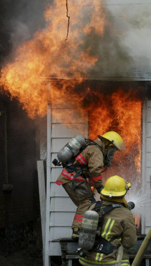 JOE BRYKSA/WINNIPEG FREE PRESS Local-(See Aldo's story)- Firefighter Darryl Hansell from Fire Station 4 kicks the rear door in at a burning home at 151 Sherbrook sunday afternoon in Winnipeg- The fire destroyed the home- (no one appeared to be injured at the scene)- Apr 29, 2002