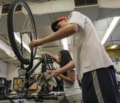 Maples Collegiate Institute students Mattias Hartfiel (left), grade 10, and Jamie Hinog, grade 11, put the finishing touches on her bike repairs in the metals workshop today - the last day of an eight week initiative to repair bikes to use and/or donate to the local community to promote active transportation. Education Minister Nacy Allan was in the shop today to announce more than $40 thousand in Education for Sustainable Development (ESD) grants for 22 such projects to promote sustainability and awareness. Tuesday, June 18, 2013. (JESSICA BURTNICK/WINNIPEG FREE PRESS)