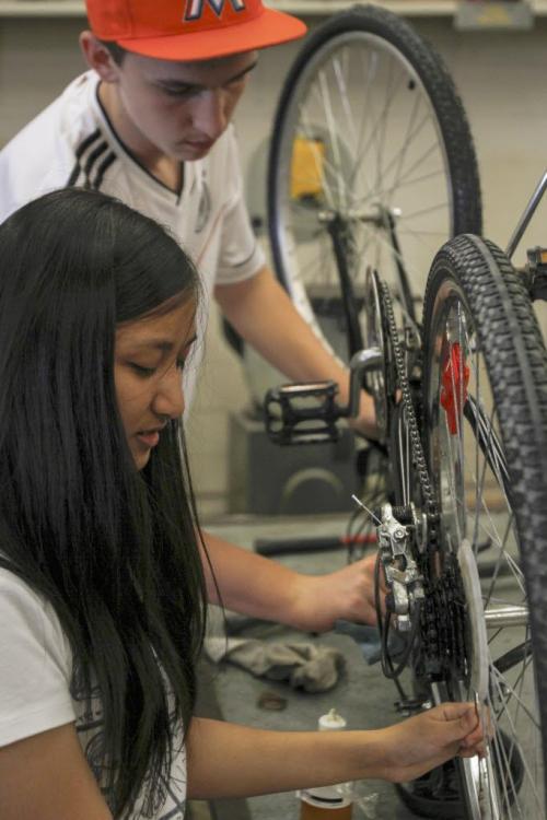Maples Collegiate Institute students Mattias Hartfiel (top), grade 10, and Jamie Hinog, grade 11, put the finishing touches on her bike repairs in the metals workshop today - the last day of an eight week initiative to repair bikes to use and/or donate to the local community to promote active transportation. Education Minister Nacy Allan was in the shop today to announce more than $40 thousand in Education for Sustainable Development (ESD) grants for 22 such projects to promote sustainability and awareness. Tuesday, June 18, 2013. (JESSICA BURTNICK/WINNIPEG FREE PRESS)