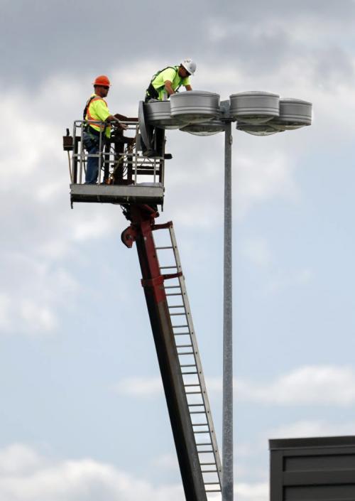 Heads in the clouds. Connelly Signs two-man crew, Jason Hyde (right) and Jason Berard, appear to be just below the cloud ceiling as they fix the lights in the Garden City Square parking lot (Leila at McPhillips) on Tuesday, June 18, 2013. (JESSICA BURTNICK/WINNIPEG FREE PRESS)