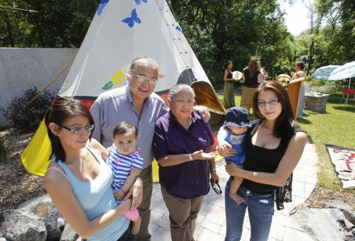 From left, Brandy Andrews with daughter Isabella, Elders Clarence and Barbara Nepinak and Victoria Dorie with son Caleb by the teepee in The Villa Rosa Outdoor Teaching Garden . Villa Rosa held a grand opening ceremony for the garden Wednesday.   Intern Elizabethstory. (WAYNE GLOWACKI/WINNIPEG FREE PRESS) Winnipeg Free Press June 19 2013