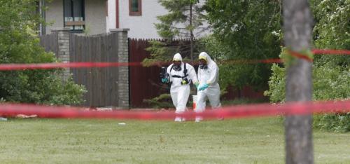 Members of the  Winnipeg Fire Paramedic Service's hazardous materials unit  in a park at Tu-Pelo Ave. near Gateway Road where a suspicious package was found Thursday. A stretch of Gateway between McLeod Avenue and Jeffrey Crescent was closed to motorists and pedestrians. (WAYNE GLOWACKI/WINNIPEG FREE PRESS) Winnipeg Free Press June 20 2013