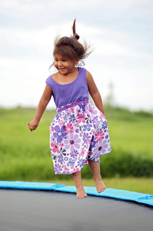 Brandon Sun 20062013 Three-year-old Esmaya Bell appears to float in the air while bouncing on a new trampoline in front of her home at Sioux Valley Dakota Nation on Thursday evening.  (Tim Smith/Brandon Sun)