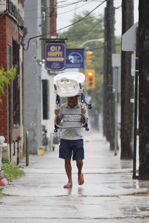 June 23, 2013 - 130623  - On Selkirk Avenue a Winnipegger gets creative with his head covering during a rain storm this afternoon Sunday, June 23, 2013. John Woods / Winnipeg Free Press