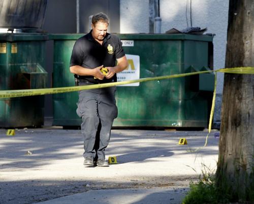 Winnipeg Police officer places evidence markers on the sidewalk on Wolseley Ave. between Sherbrook St. and Furby St. Monday after  an early morning shooting.Adam Wazny story (WAYNE GLOWACKI/WINNIPEG FREE PRESS) Winnipeg Free Press June 24 2013