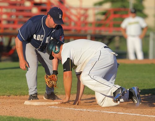 Brandon Sun Rockets' Rory Tycoles attempts the pick-off at first on Cloverleafs' Kyal Williams during Monday's game at Andrews Field. (Bruce Bumstead/Brandon Sun)