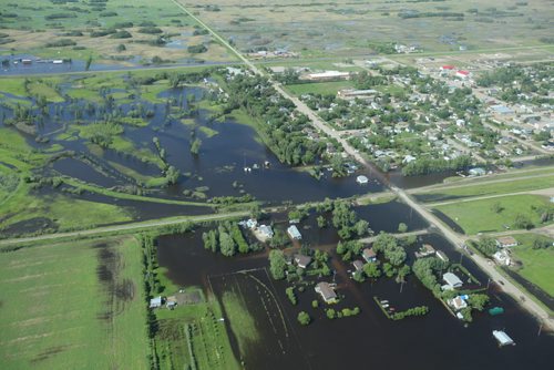 Brandon Sun 26062013 Water inundates the community of Reston, Manitoba, flooding homes on the west side of the community as seen from the air on Wednesday. (Tim Smith/Brandon Sun)