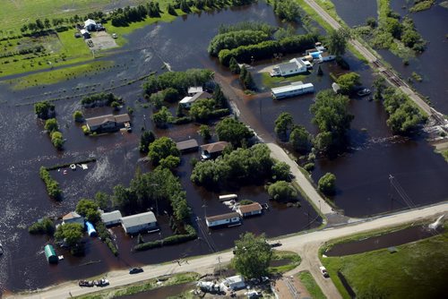 Brandon Sun 26062013 Homes in the community of Reston, Manitoba are inundated with water after severe flooding as seen from the air on Wednesday. (Tim Smith/Brandon Sun)