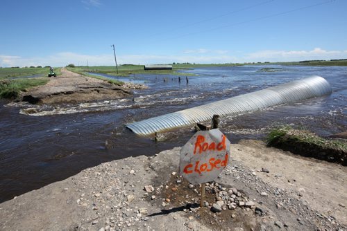 Brandon Sun 26062013 A grid road in the RM of Albert is marked closed on Wednesday after flood waters washed away a portion of the road and the underlying culverts.   (Tim Smith/Brandon Sun)