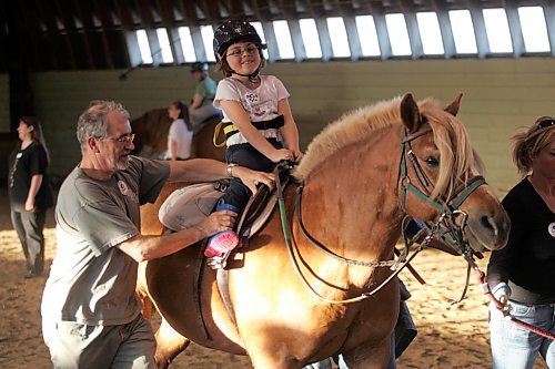 BORIS MINKEVICH / WINNIPEG FREE PRESS  070507 Manitoba Riding for the Disabled at Meadow Green Stable. Kyla Cross,7, rides on a horse with volunteers from the program helping.