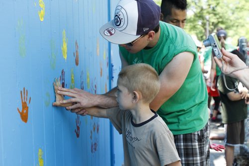 Neighbourhood children put their handprints on a freshly painted building at Machray Park on Anderson Ave. on Thursday, July 4, 2013. The project launched the Take Pride Winnipeg annual summer employment program, which employs students aged 16-19 to assist in keeping the city clean and beautiful. (JESSICA BURTNICK/WINNIPEG FREE PRESS)