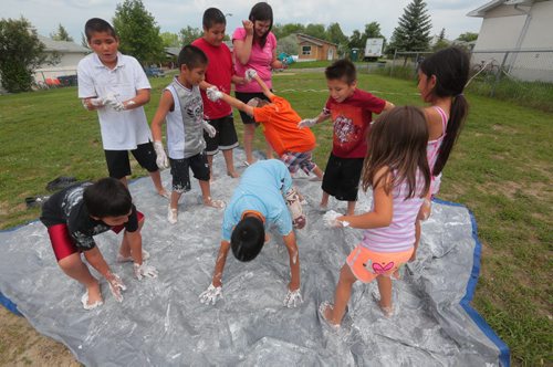 Brandon Sun Neighbourhood kids let loose with a shaving cream slip-n-slide at the Westaway Bay park during the first day of a summer recreation program on Thursday afternoon. (Bruce Bumstead/Brandon Sun)