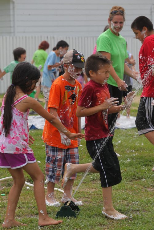 Brandon Sun Neighbourhood children rinse off shaving cream in a sprinkler at the Westaway Bay park during a community enhancement project on Thursday afternoon. In conjunction with a variety of organizations, including the  Brandon School Division, Brandon Regional Health Authority, Child and Family Services Westman, Samaritan House and Manitoba Housing, partnered with the Elspeth Reid to help with the first day of their summer recreation program at west end park. (Bruce Bumstead/Brandon Sun)