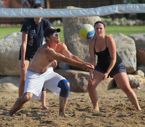 Brandon Sun Andrew Stevenson plays the ball for the Blocking Dead as teammate Amanda Green looks on during Thursday night's beach volleyball league action at Mulligans Driving Range. (Bruce Bumstead/Brandon Sun)