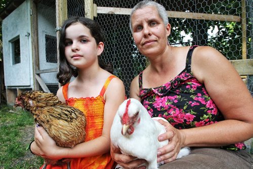 Stacie Gottfried with her daughter Shanti and two of the five hens, Jumpy (left) and Ono (right), they have in a backyard coop.  130704 July 04, 2013 Mike Deal / Winnipeg Free Press