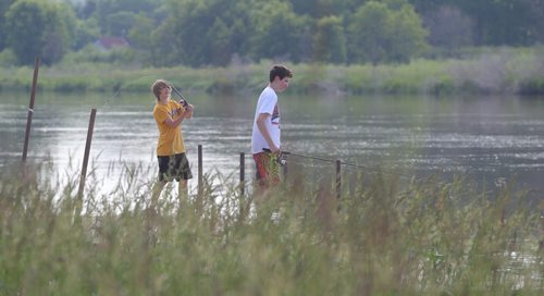 Brandon Sun Friends Paul MacKay and Nolan May, right, spend the afternoon fishing along the Assiniboine River near Disdale Park on Friday. (Bruce Bumstead/Brandon Sun)