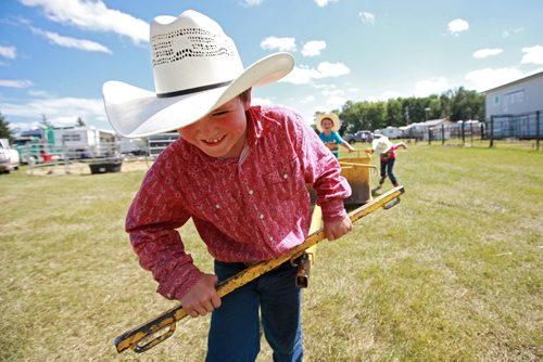 Brandon Sun 07072013 Holden Fullerton pulls his friends in a chariot during the 130th Carberry Fair and Races on a hot Sunday afternoon. (Tim Smith/Brandon Sun)