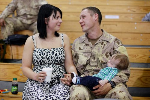 Brandon Sun 08072013 Corporal Dan Gardiner visits with his wife Callie and their son Bohdan in the Multi-Purpose Training Facility at CFB Shilo on Monday morning prior to deploying to Kabul as part of the final rotation of Canadian soldiers serving in Afghanistan. Gardiner's deployment, his first to Afghanistan, will be approximately four month's.  (Tim Smith/Brandon Sun)